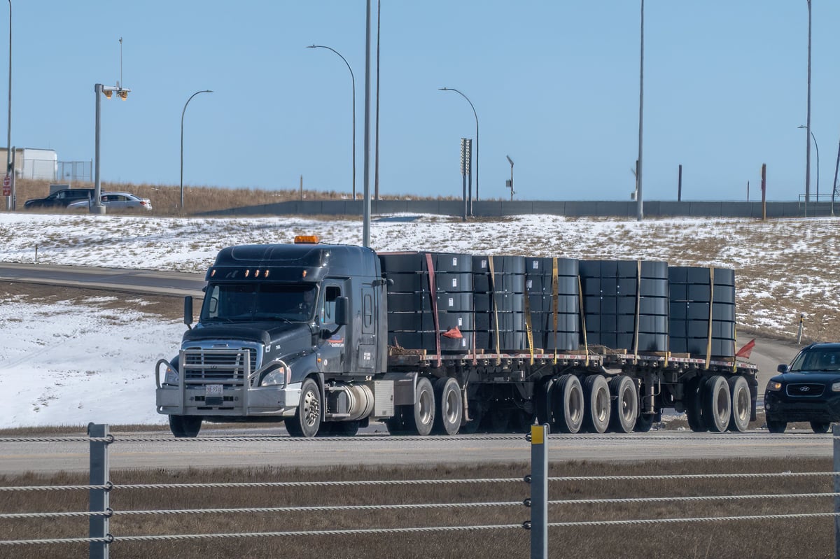 American semi truck pulling an open flatbed trailer loaded with freight on a U.S. highway